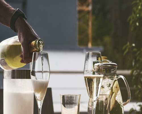A glass of fresh water placed gracefully next to a plate on a wooden dining table